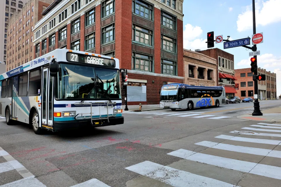 City bus in downtown Kansas City with brick buildings in background.